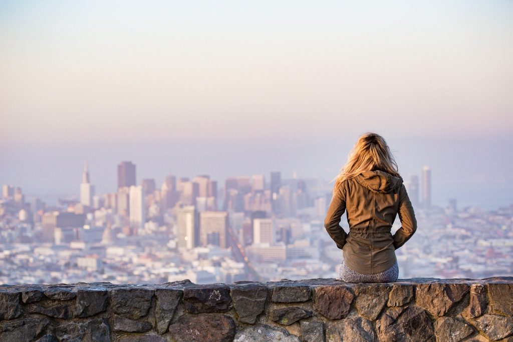 lady sitting on a wall looking at a view.