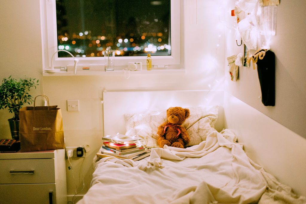 childs bed with a teddy bear.